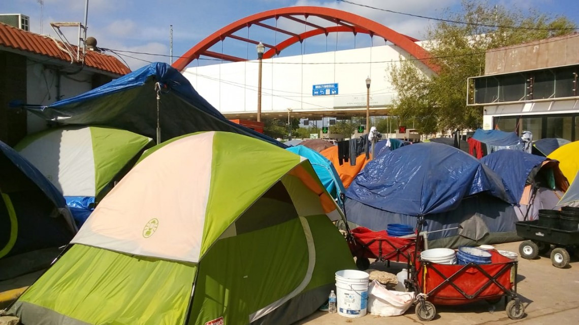 Migrantes se niegan a moverse de la plaza del puente Nuevo 